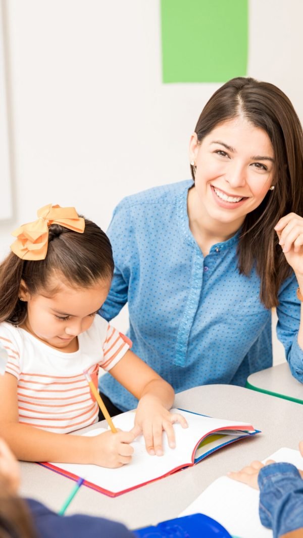 Portrait of a gorgeous Hispanic preschool teacher teaching her students in a classroom